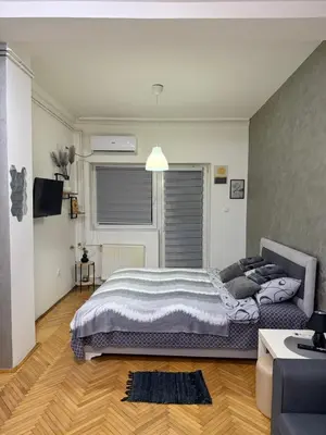a bedroom with a large bed and a couch at Loli apartman in Kraljevo