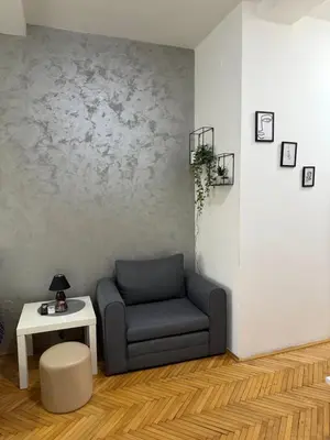 a living room with a chair and a table at Loli apartman in Kraljevo