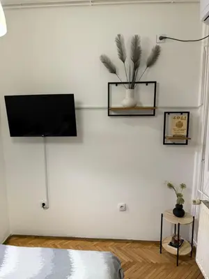 a living room with a tv on a white wall at Loli apartman in Kraljevo