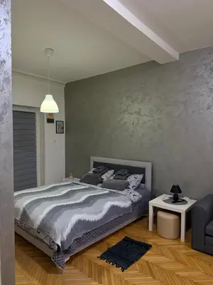 a bedroom with a bed and a couch and a table at Loli apartman in Kraljevo