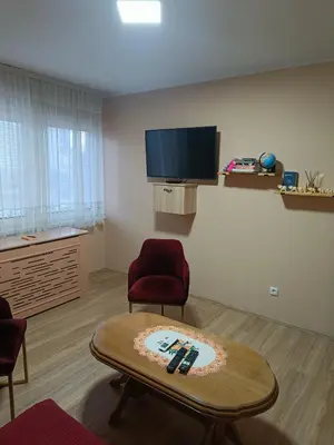 a living room with a table and a flat screen tv at Apartman Putnik in Vrnjačka Banja