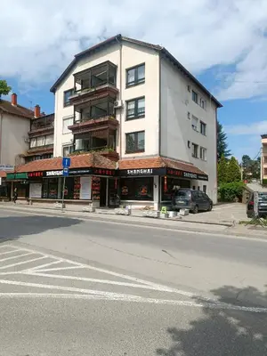 a tall white building on the corner of a street at Apartman Putnik in Vrnjačka Banja