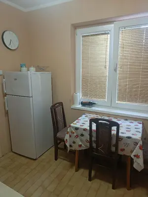 a kitchen with a table and a white refrigerator at Apartman Putnik in Vrnjačka Banja