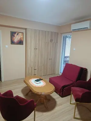 a living room with a red couch and a table at Apartman Putnik in Vrnjačka Banja