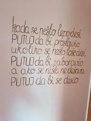 a writing on the side of a white wall at Apartman Putnik in Vrnjačka Banja