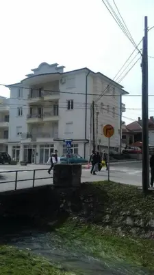 a building on a street with people walking on the street at Marta i Marija in Vrnjačka Banja