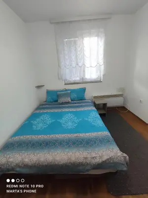 a bedroom with a blue bed with a window at Marta i Marija in Vrnjačka Banja
