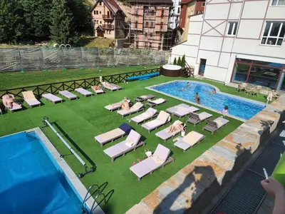 an overhead view of a swimming pool with chaise lounges and people sitting at Ebra 76 Kraljevi Cardaci Kopaonik in Kopaonik