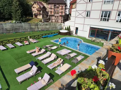 an overhead view of a pool with chaise lounge chairs and people in a yard at Ebra 76 Kraljevi Cardaci Kopaonik in Kopaonik
