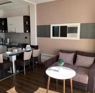 a living room with a couch and a table and a kitchen at Milmari I2 Studio LUX Apartman in Kopaonik