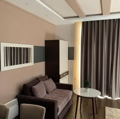 a living room with a couch and a table at Milmari I2 Studio LUX Apartman in Kopaonik