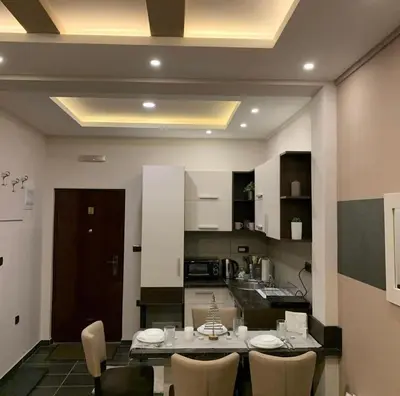 a kitchen with a table and chairs in a room at Milmari I2 Studio LUX Apartman in Kopaonik