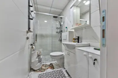 a white bathroom with a shower and a toilet at MED Apartmani in Vrnjačka Banja
