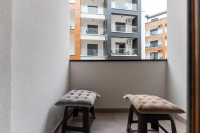 two stools in front of a window with a building at MED Apartmani in Vrnjačka Banja