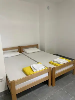 two beds in a room with yellow towels on them at Vile Jana in Leskovac