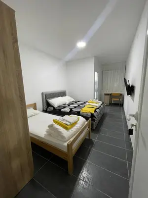 a room with two beds and a table in it at Vile Jana in Leskovac