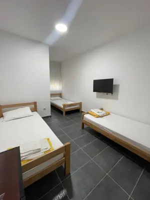 a room with two beds and a flat screen tv at Vile Jana in Leskovac