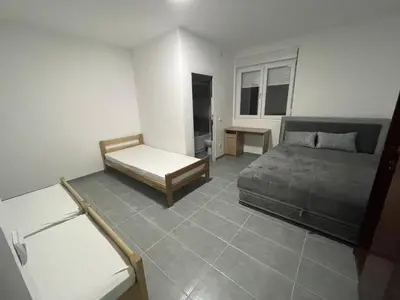 a bedroom with a bed and a table in it at Vile Jana in Leskovac