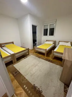 a room with three beds in it with yellow sheets at Vile Jana in Leskovac