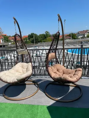 two rocking chairs sitting on a patio with a pool at Vile Jana in Leskovac
