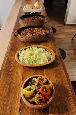 a long wooden table with three pizzas on it at Gore Dole in Donji Matejevac