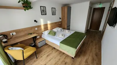 a bedroom with a bed and a desk and a chair at Gore Dole in Donji Matejevac