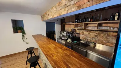 a bar with a counter and stools in a room at Gore Dole in Donji Matejevac