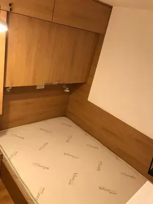 a bed in a room with a cupboard at Planinski Raj - Bela Reka Gondola in Brzeće