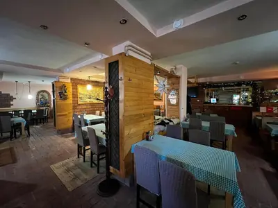 a dining room with tables and chairs in a restaurant at ZIMSKI Apartmani in Kopaonik