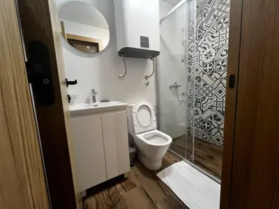 a small bathroom with a toilet and a shower at ZIMSKI Apartmani in Kopaonik