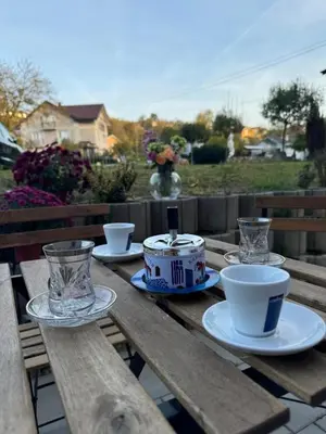 a wooden picnic table with cups and glasses on it at Vila Lela in Vrnjačka Banja