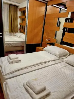 two beds in a hotel room with towels on them at Apartman KUTIJA Kopaonik in Kopaonik