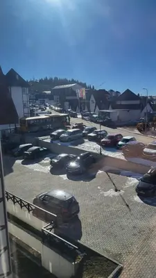 a parking lot with cars parked in a parking lot at Apartman KUTIJA Kopaonik in Kopaonik