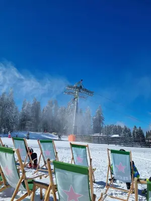 a group of chairs in the snow with a ski lift at Apartman KUTIJA Kopaonik in Kopaonik