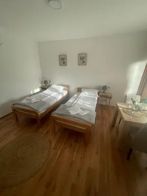 two beds in a room with a wooden floor at Temački konaci in Pirot