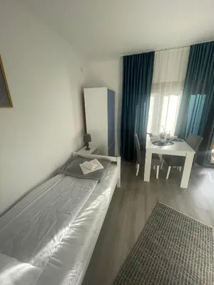 a bedroom with a bed and a desk and a table at Temački konaci in Pirot