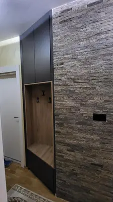 a wooden cabinet against a brick wall at Apartman POSEJDON DELUXE 2 in Vrnjačka Banja
