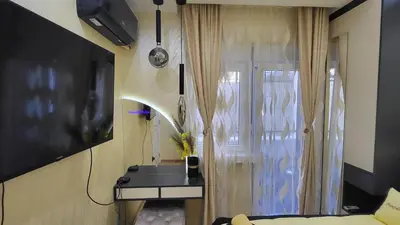 a living room with a television and a window at Apartman POSEJDON DELUXE 2 in Vrnjačka Banja