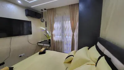 a bedroom with a bed and a flat screen tv at Apartman POSEJDON DELUXE 2 in Vrnjačka Banja