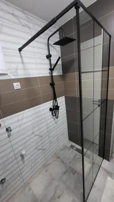 a shower with a glass door in a bathroom at Apartman POSEJDON DELUXE 2 in Vrnjačka Banja