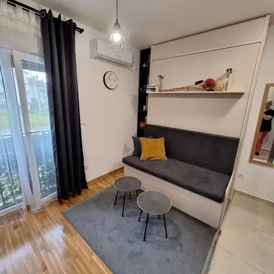 a living room with a couch and two tables at studio-apartman ,,ISSA,, in Vrnjačka Banja
