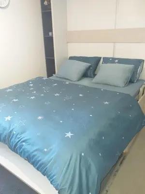 a bed with a blue comforter with stars on it at studio-apartman ,,ISSA,, in Vrnjačka Banja