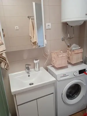 a bathroom with a washing machine and a sink at studio-apartman ,,ISSA,, in Vrnjačka Banja
