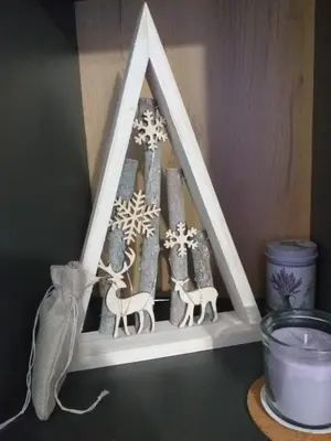 a shelf with a picture of a christmas pyramid with a cat at studio-apartman ,,ISSA,, in Vrnjačka Banja