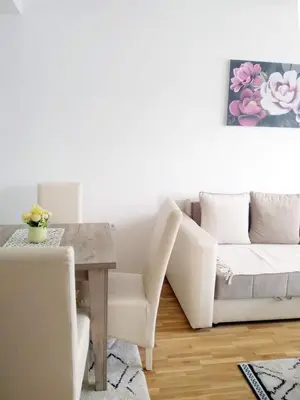 a living room with a white couch and a table at Apartman Filipović Vrnjačka Banja in Vrnjačka Banja