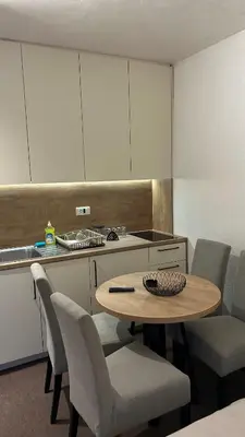 a kitchen with a table and chairs and a counter at Apartmani Haski Konaci in Kopaonik