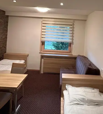 a room with two beds and a window at Apartmani Haski Konaci in Kopaonik