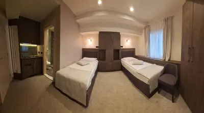 a hotel room with two beds and a television at Apartmani Haski Konaci in Kopaonik
