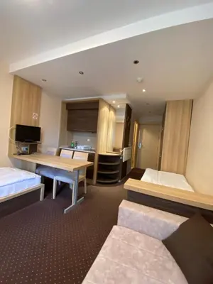 a hotel room with two beds and a kitchen at Apartmani Haski Konaci in Kopaonik