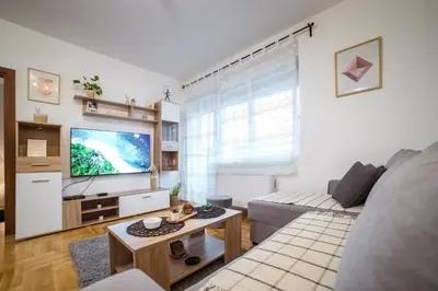 a living room with a couch and a flat screen tv at Lux Apartmani Rakić in Pirot